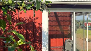 Une structure en bois rouge, dotée d’une porte en verre et d’un sol à motifs.