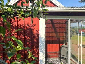 Eine rote Holzkonstruktion mit Glastür und einem gemusterten Boden.