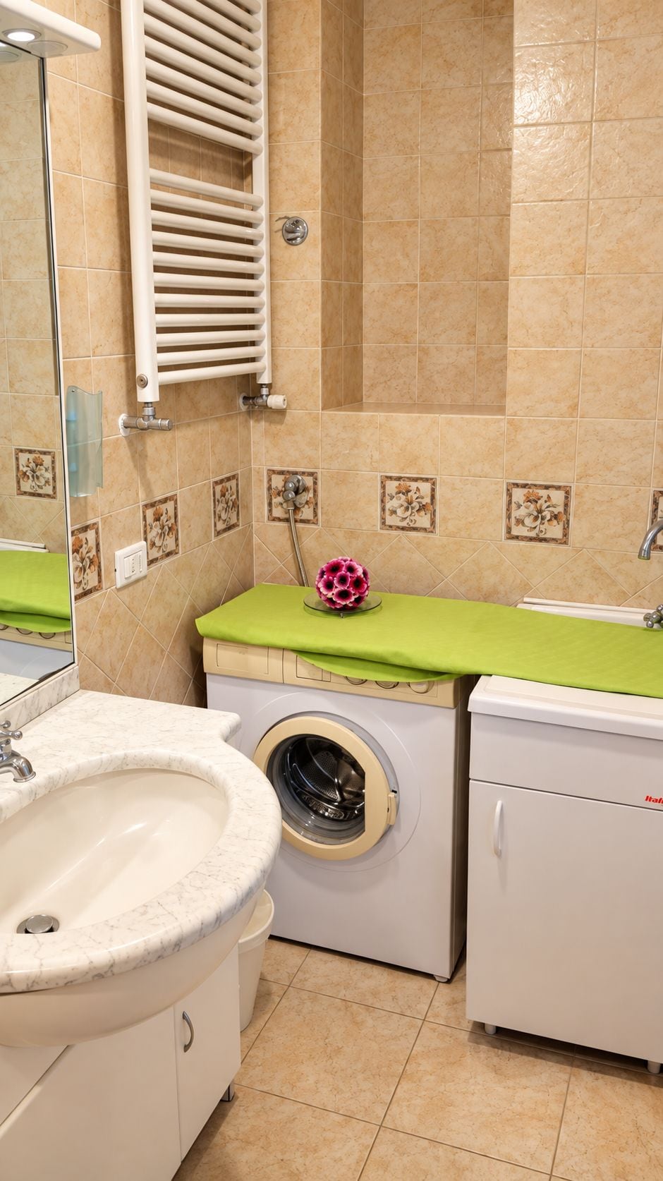 A bathroom with a sink, a washing machine, and a dryer.