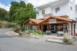 A white building with a sign for 'RENT ROOMS DIONYSIOS' and 'TAVERNIA DIONYSIOSOS' offering traditional food. - Room 'Hestia' with Wi-Fi (Lasithiou)