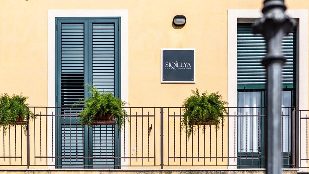 A building facade with a sign reading 'SIOILLYA' and two windows with shutters. - Siqillya Etna Linguaglossa (Linguaglossa)