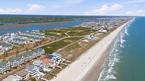A coastal hotel with multiple buildings, a beach, and a view of the ocean. - unobstructed ocean views-pool club-private bath for each bedroom-elevator-parking 4 cars-golf cart friendly<br>APRIL '26 UPDATES- new floors, paint, HVAC, renovated walk in shower (Ocean Isle Beach)