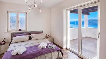 Un dormitorio con cama, mesita de noche y ventana, con vistas al exterior.