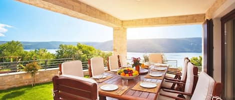 Villa familiar, varias habitaciones, frente al mar (Villa Royal Blue) | Restaurante al aire libre