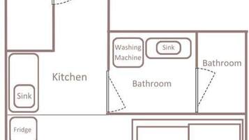 A hotel room layout with an entrance, two bathrooms, a kitchen, a king bed, a single bed, a sofa, a TV, and two tables.