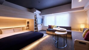 A modern hotel room with a bed, a desk, a chair, a sofa, and a window with blinds. - Minn Namba South (Osaka)