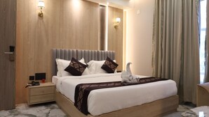 A modern hotel room with a large bed, bedside tables, and a nightstand. - Hotel Global Inn Keonjhar (Ghatagaon)