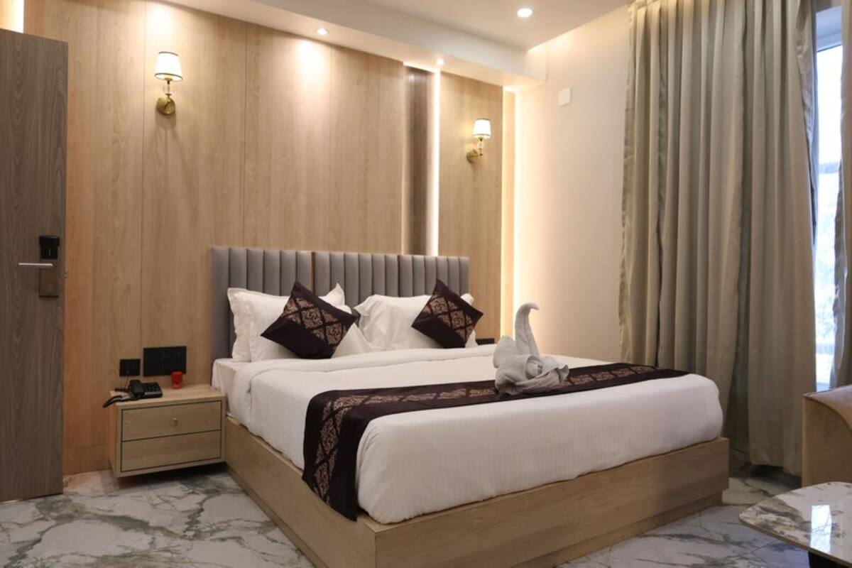 Una habitación de hotel moderna con una cama grande, mesitas de noche y una mesilla.