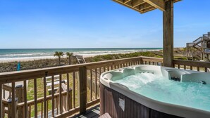 A wooden deck with a hot tub overlooking a beach. - Oceanfront | Shared Pool | Beach Access | Hot Tub (North Topsail Beach)