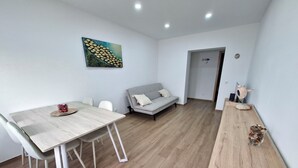 Un soggiorno moderno con zona pranzo, divano e un quadro appeso al muro.