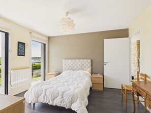 A bedroom with a bed, bedside tables, a desk, and a chair. - Direct sea access - Charming house for 8 (Plouguerneau)