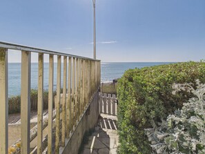 A coastal walkway with metal railings, a concrete path, and dense foliage. - Stunning sea view with terrace, 2 adults 2 children (Saint-Hilaire-de-Riez)