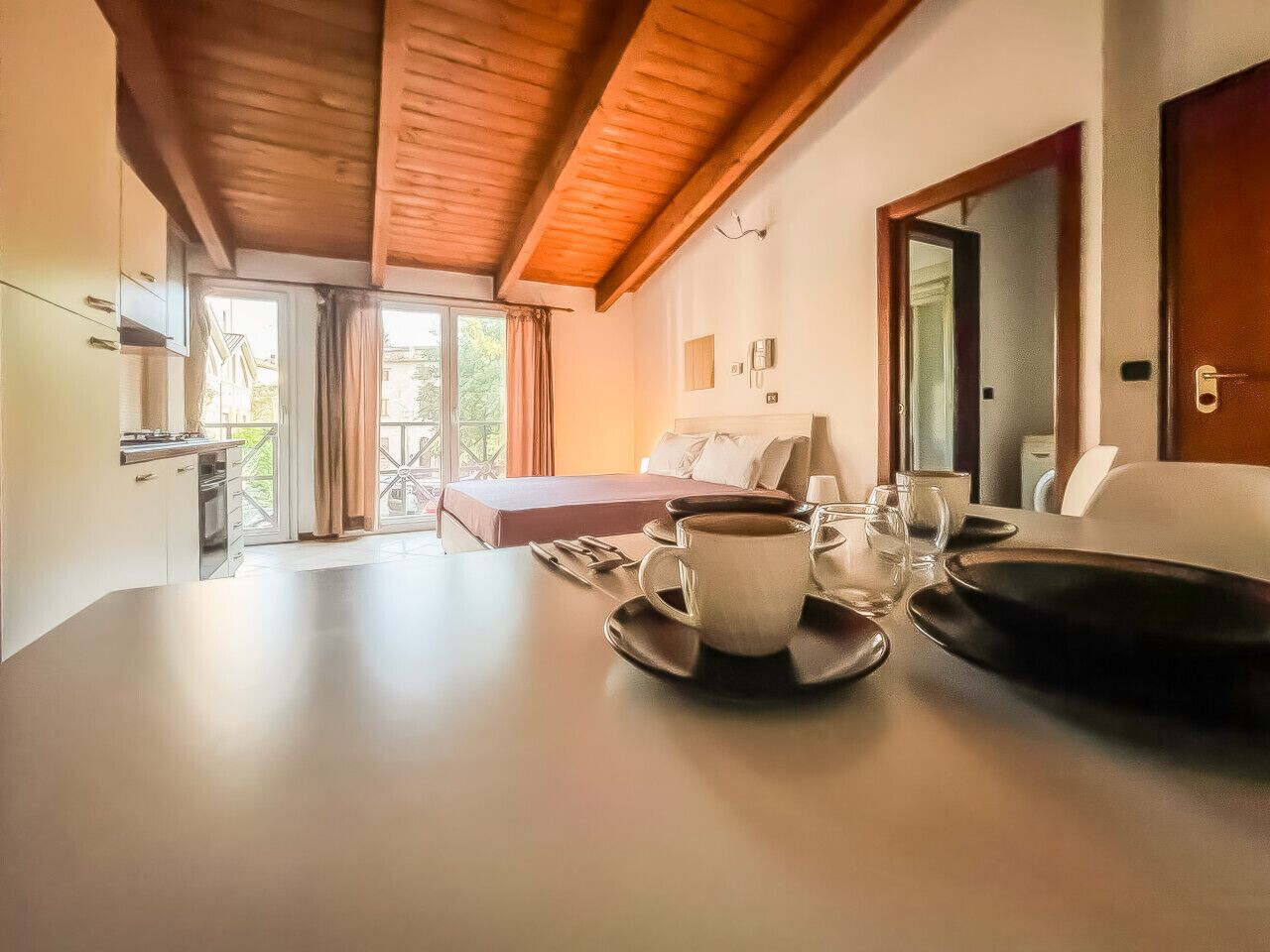 Una mesa de comedor con una taza y platillo, un plato negro y una silla.