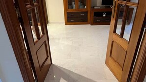 A room with a wooden door, a tiled floor, and a cabinet with glass doors. - Villa Juani in Playa Los Alamos (Torremolinos)