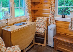A cozy cabin room with a wooden desk, a chair, a radiator, and a window with curtains. - 1 bedroom accommodation in Blaenau Ffestiniog (Blaenau Ffestiniog)