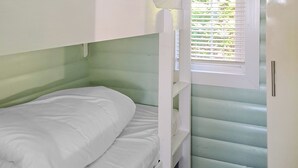 A bunk bed with white bedding, a window with blinds, and a door with a handle. - 2 bedroom accommodation in Blaenau Ffestiniog (Blaenau Ffestiniog)