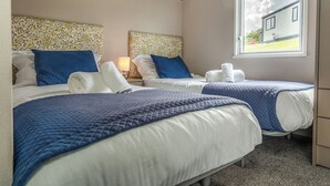Une chambre d’hôtel avec deux lits, une fenêtre donnant sur un beau paysage et un plafond en bois.