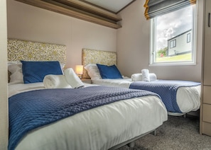 A hotel room with two beds, a window with a view, and a wooden ceiling. - 2 bedroom accommodation in Mawgan Porth, Nr Newquay (Mawgan Porth, Nr Newquay)