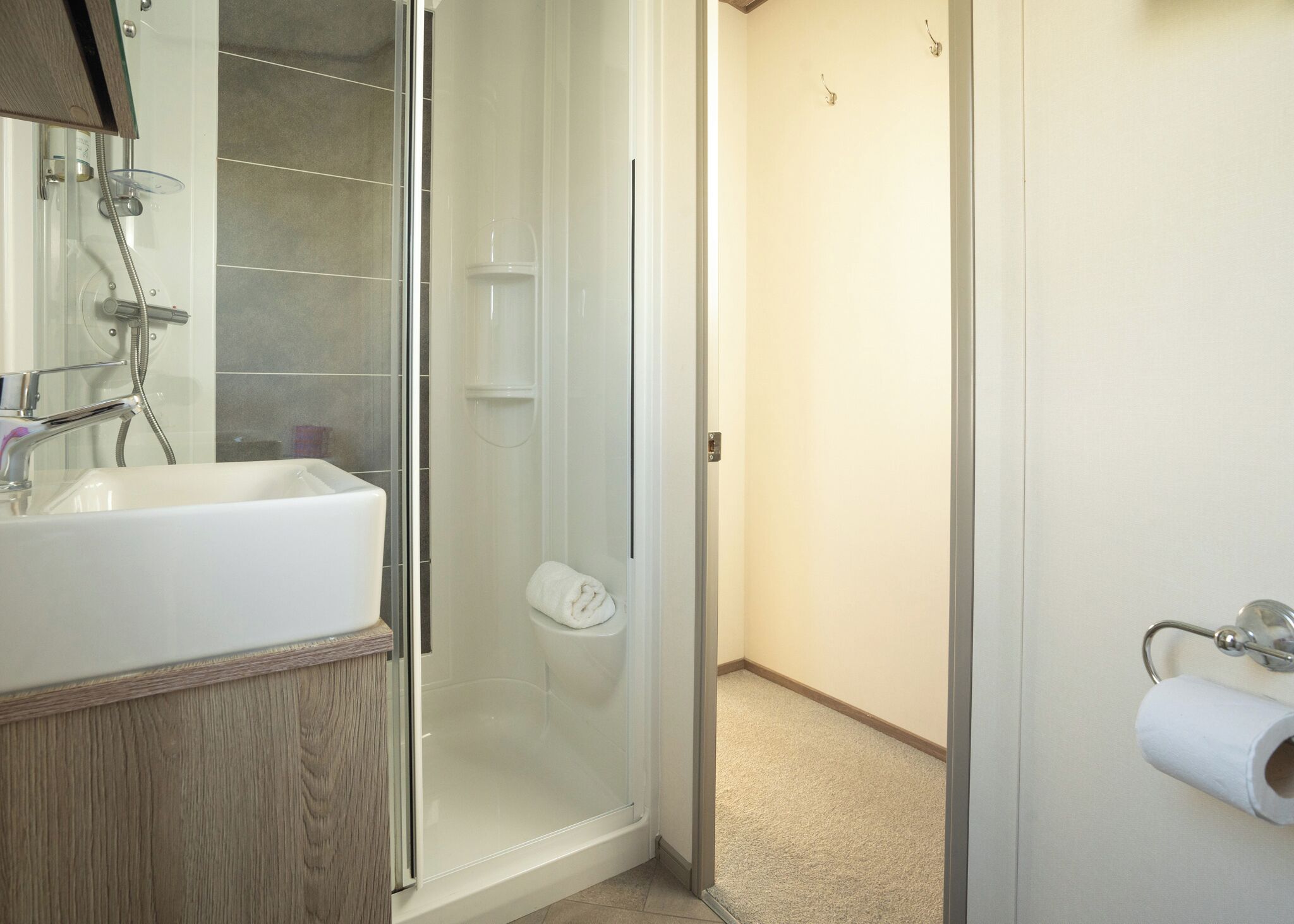 Ein Badezimmer mit Duschkabine, Waschbecken und Toilette.