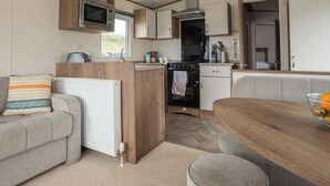 Una cucina compatta per camper, con forno a microonde, fornello e lavello.