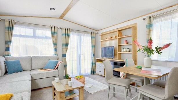 Een moderne woonkamer met een bank, salontafel, televisie, eettafel met stoelen en een boekenkast.