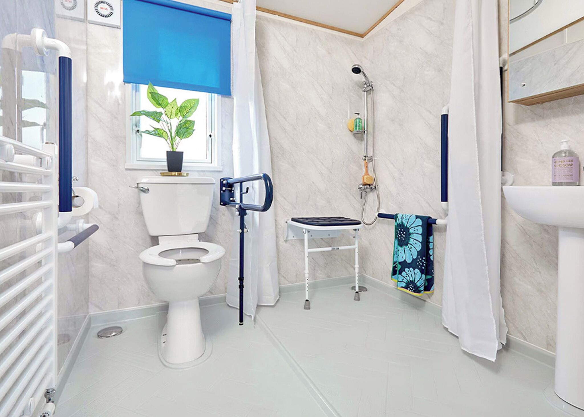 Une salle de bain moderne équipée de toilettes, d’un bidet, d’une douche et d’une petite table sur laquelle est posée une serviette.