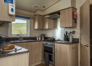 Fridge, oven, stovetop, toaster - The Superior 3 Bedroom is a comfortable and spacious sleeps 8 caravan. (Mawgan Porth, Nr Newquay)