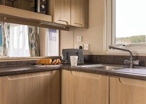 Fridge, oven, stovetop, toaster - The Superior 3 Bedroom is a comfortable and spacious sleeps 8 caravan. (Mawgan Porth, Nr Newquay)