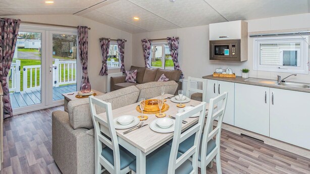 A cozy living area with a sofa, dining table, and kitchen.