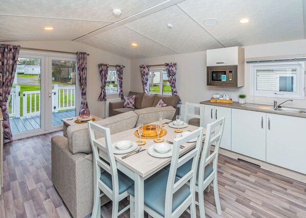 A cozy living area with a sofa, dining table, and kitchen.