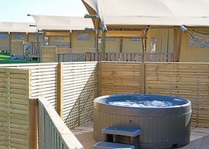 A hot tub with a wooden deck and a covered area with a canopy. - The Woody Safari Tent (Landford, Nr Salisbury)