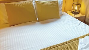 A neatly made bed with white linens and two large pillows, a bedside table with a lamp, and a folded white towel on the bed. - The Woody Safari Tent (Pet) (Landford, Nr Salisbury)