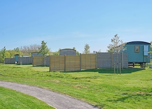 A row of mobile homes with a wooden fence in the foreground. - 1 bedroom accommodation in Landford, Nr Salisbury (Landford, Nr Salisbury)