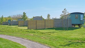 Een rij mobiele woningen met een houten omheining op de voorgrond.