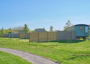 A row of mobile homes with a wooden fence in the foreground. - 1 bedroom accommodation in Landford, Nr Salisbury (Landford, Nr Salisbury)