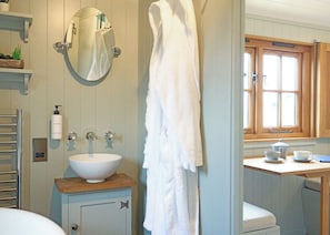 A bathroom with a white sink, a mirror, a towel rack, a window, and a wooden countertop. - 1 bedroom accommodation in Landford, Nr Salisbury (Landford, Nr Salisbury)
