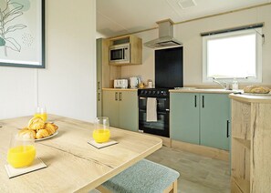 Eine moderne Küche mit Esstisch, Frühstücksangebot und einem Fenster.