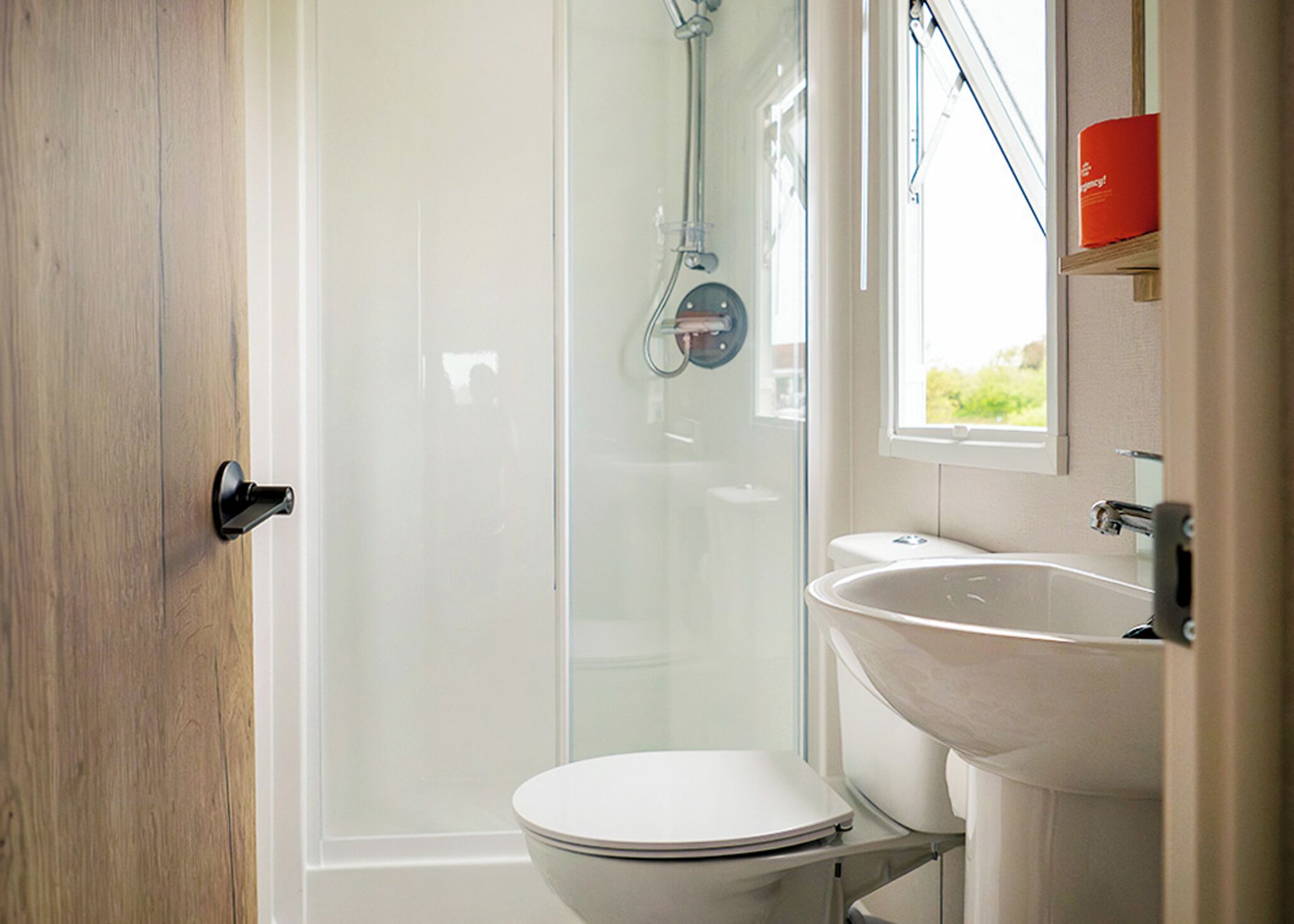 Ein Badezimmer mit Toilette, Waschbecken und einer Duschkabine aus Glas.