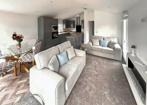 Un salon moderne avec un canapé, une table basse et une cheminée.