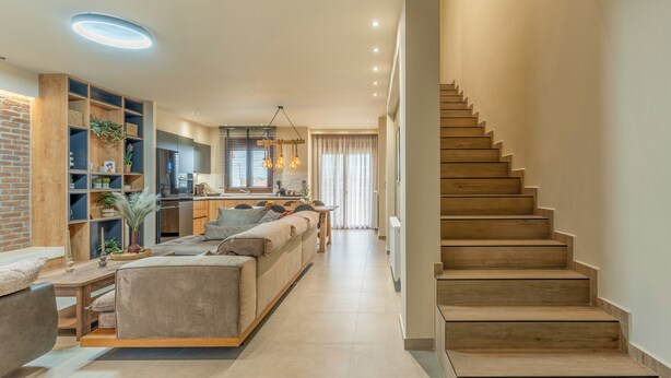 Una sala de estar moderna con un sofá, una mesa de centro y una escalera.