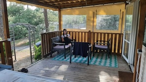 A covered porch with wooden railings, a bench, and a table. - Complete accommodation. Accommodation.  Cap Ferret max. 6 persons (Lège-Cap-Ferret)