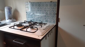 A kitchen with a gas stove, a coffee maker, and a patterned backsplash. - Complete accommodation. Accommodation.  Cap Ferret max. 6 persons (Lège-Cap-Ferret)