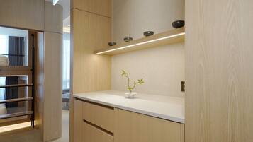A modern interior with wooden cabinetry, a white countertop, and a small potted plant.