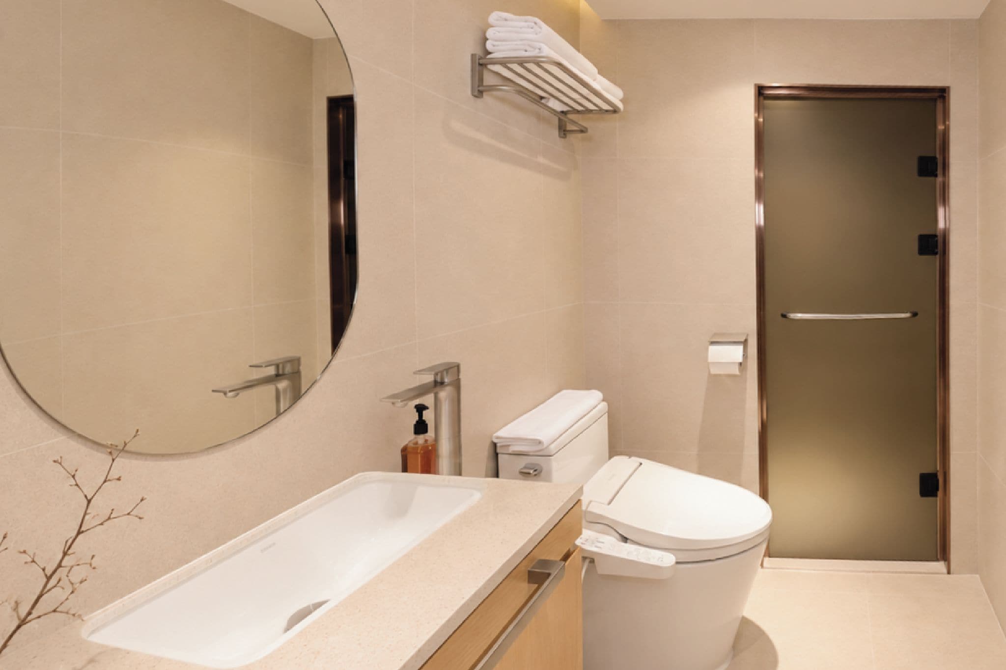 A modern bathroom with a large mirror, a white sink, a toilet, and a towel rack.