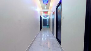 Pasillo de hotel con piso de mármol, una lámpara de araña y una puerta que indica 'STREET ROOM'.