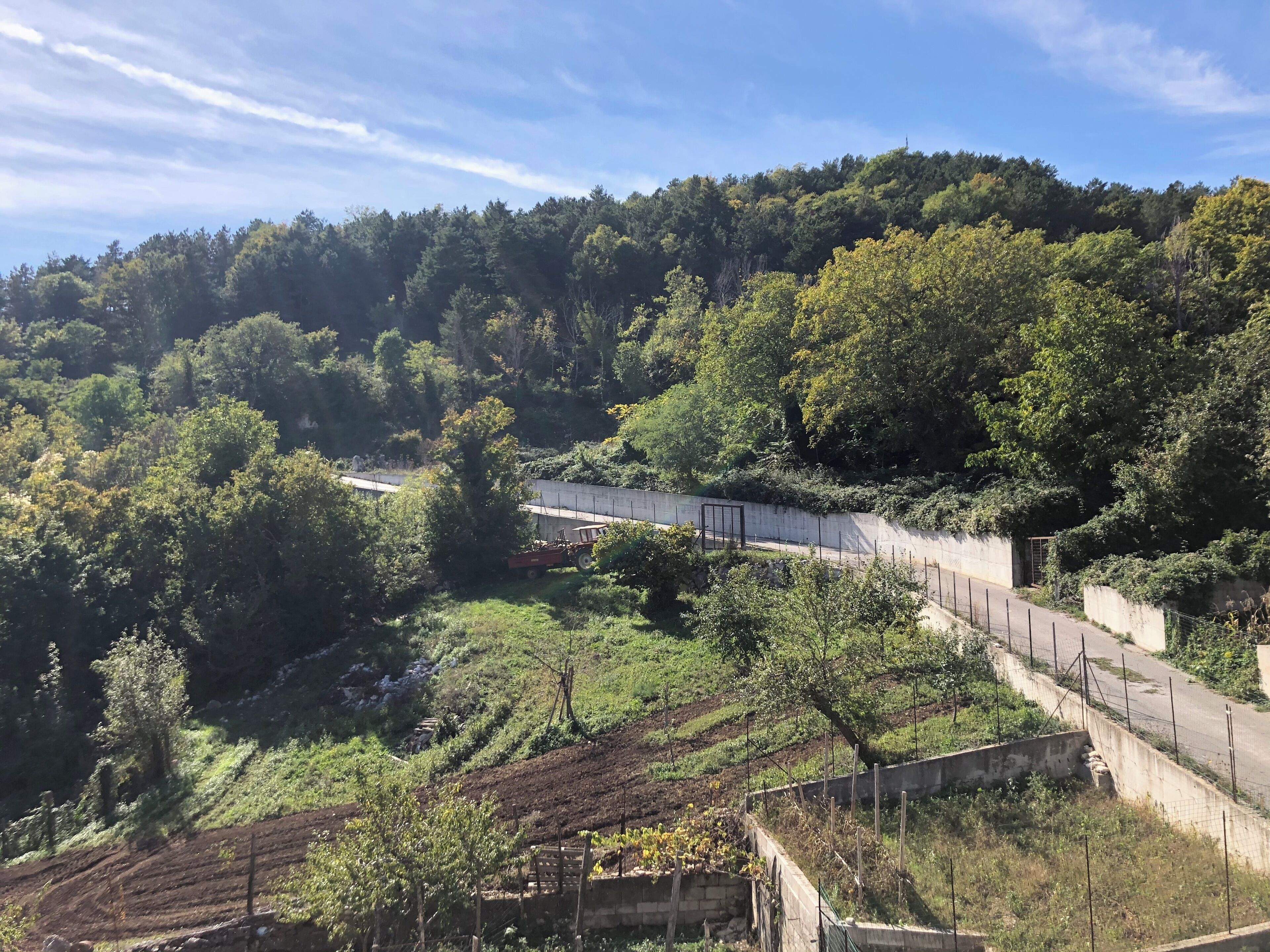 Une colline avec une route, une clôture et une construction abritant une chaise.