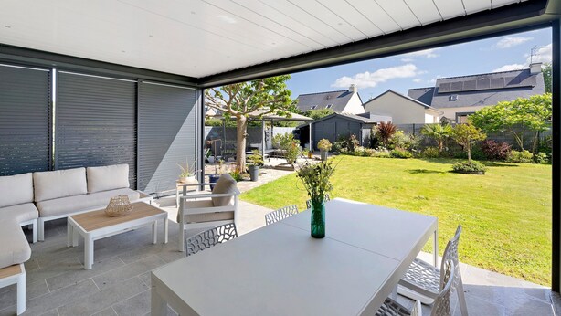 An outdoor patio with a white sofa, a table, and a vase of flowers. - Guest Room “Chambre Saint-Samson-sur-Rance” with Private Terrace, Garden & Wi-Fi (Saint-Samson-sur-Rance)