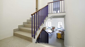 Una escalera con barandas moradas que sube a un segundo piso.