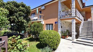 A multi-story building with balconies, a staircase, and potted plants. - Spacious ground-floor flat in Umag (Umag)