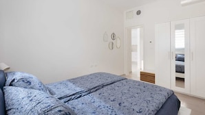 A bedroom with a bed, a wardrobe, and a ceiling fan.